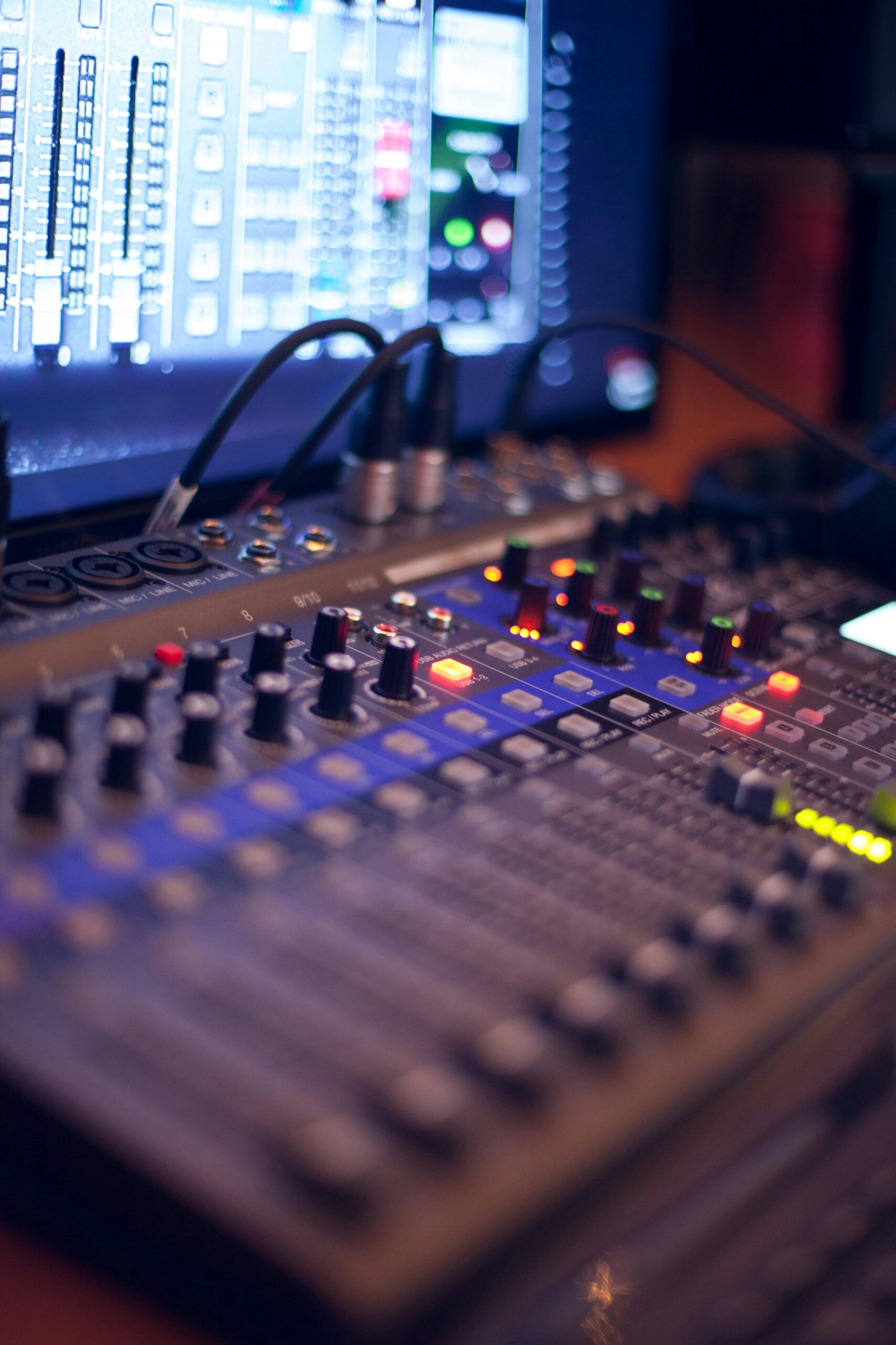 pexels-photo-1436141-1436141 Close-up of a professional audio mixing console with glowing LED indicators.
